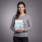 Woman holding skincare products against a gray background